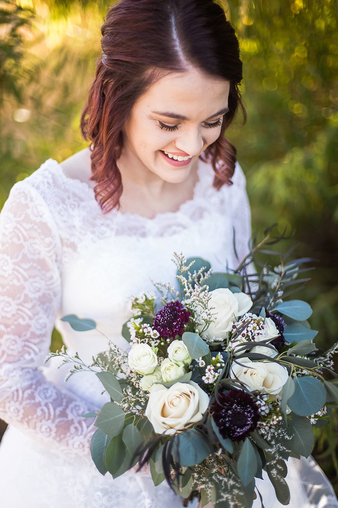 bride wearing heirloom wedding dress surrounded by flowers